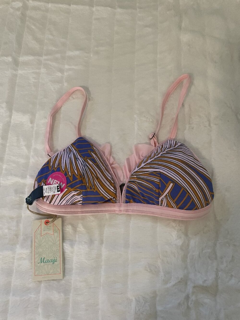 A pink, blue, yellow and white palm print brattle bikini top